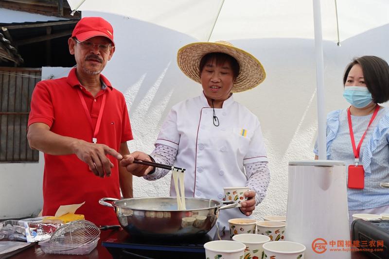 4 台湾牛肉面行家詹莫里(左一)到场指导村民做面条.jpg